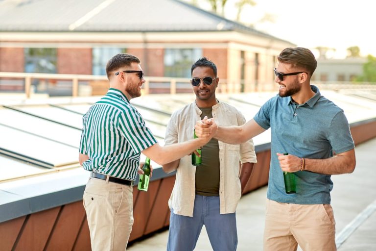 happy male friends drinking beer rooftop party